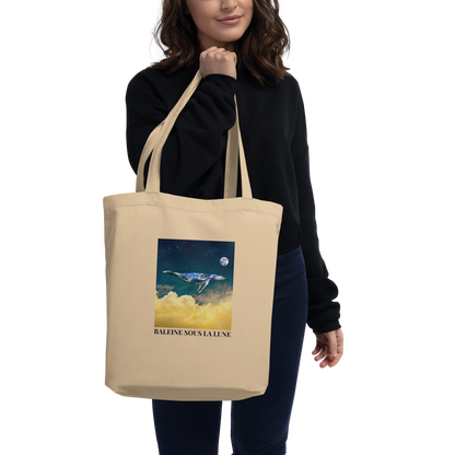 Woman Carrying a Oyster Colored Whale Eco Tote Bag featuring a majestic Whale Under The Moon graphic - Shop Cool Organic Cotton Tote Bags Online - Boozy Fox