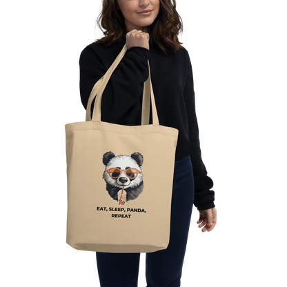 Woman carrying a Oyster Colored Panda Eco Tote Bag featuring a hilarious Eat, Sleep, Panda, Repeat graphic - Funny Organic Cotton Totes - Boozy Fox