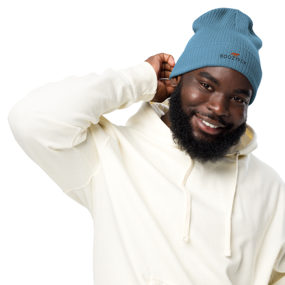 Smiling man wearing a Light Avio Blue Organic Ribbed Beanie With An Embroidered Boozy Fox Logo On Fold - Shop Organic Cotton Beanies Online - Boozy Fox