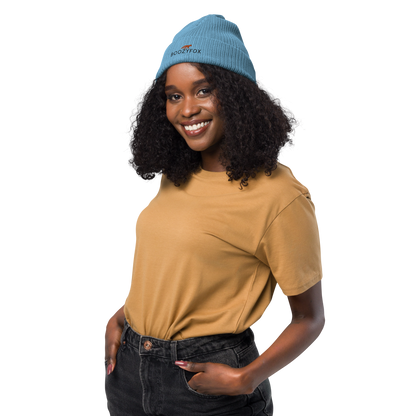 Smiling woman wearing a Light Avio Blue Organic Ribbed Beanie With An Embroidered Boozy Fox Logo On Fold - Shop Organic Cotton Beanies Online - Boozy Fox
