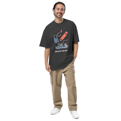 Smiling man wearing a Faded Black Skate or Die Oversized T-Shirt featuring a fearless Skeleton Falling While Skateboarding graphic on the chest - Cool Graphic Skeleton Oversized Tees - Boozy Fox