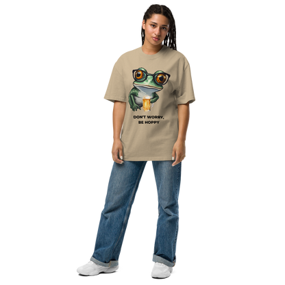 Woman wearing a Faded Khaki Frog Oversized T-Shirt featuring a ribbitting Don't Worry, Be Hoppy graphic on the chest - Funny Graphic Frog Oversized Tees - Boozy Fox