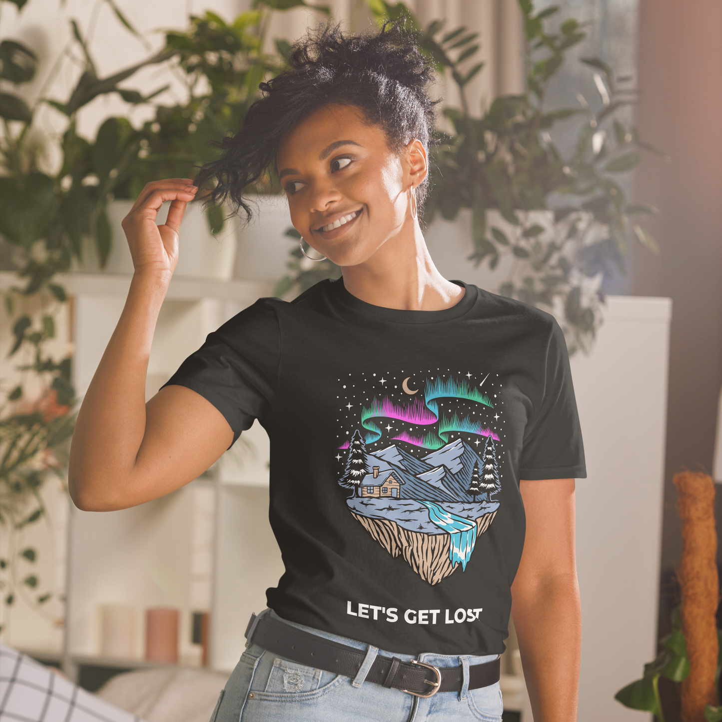 Smiling woman wearing a Black Let's Get Lost T-Shirt featuring a mesmerizing night sky, adorned with stars and aurora borealis graphic on the chest - Cool Graphic Northern Lights T-Shirts - Boozy Fox