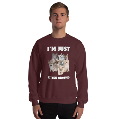 Man wearing a Maroon Cat Sweatshirt featuring an I'm Just Kitten Around graphic on the chest - Funny Graphic Cat Sweatshirts - Boozy Fox