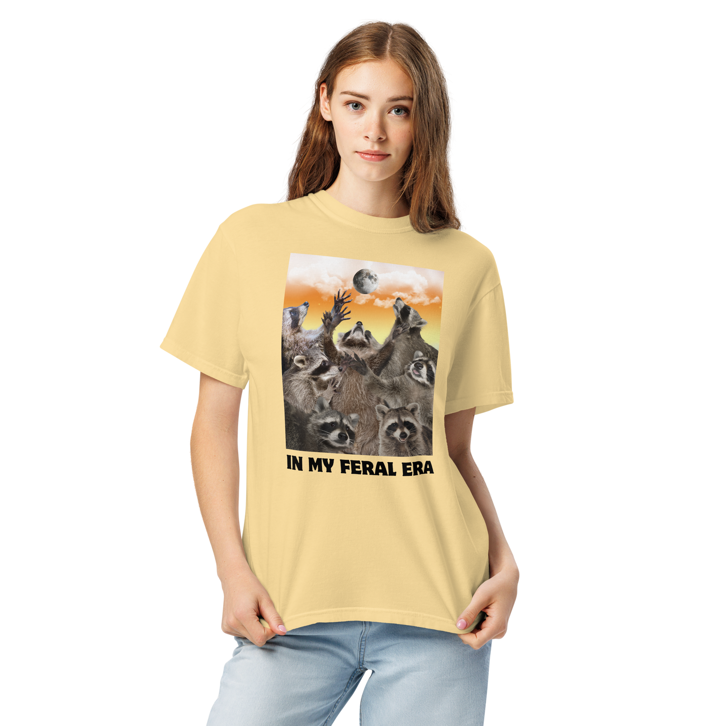 Woman wearing a Funny In My Feral Era Raccoon heavyweight graphic t-shirt in butter yellow by Boozy Fox