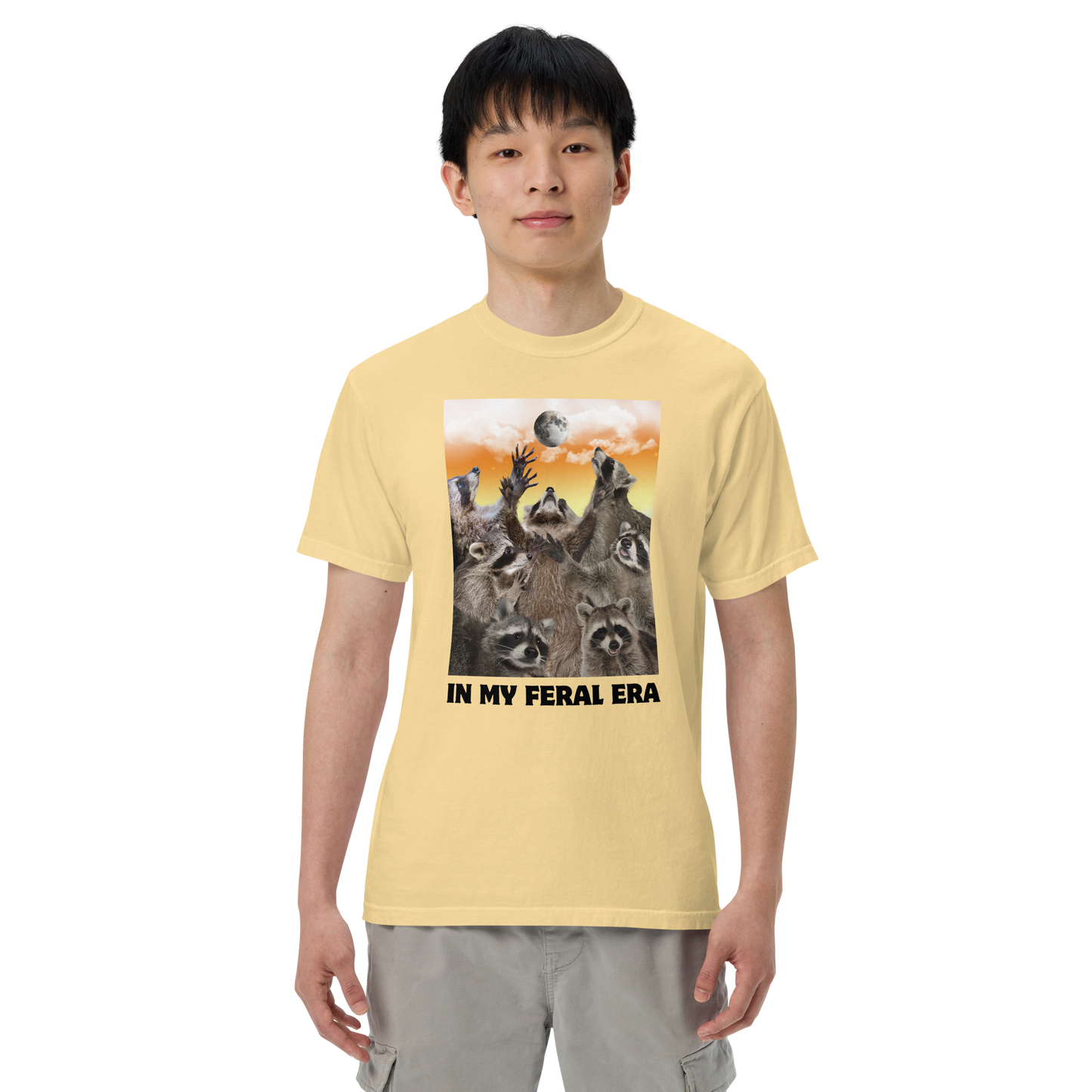 Man wearing a Funny In My Feral Era Raccoon heavyweight graphic t-shirt in butter yellow by Boozy Fox