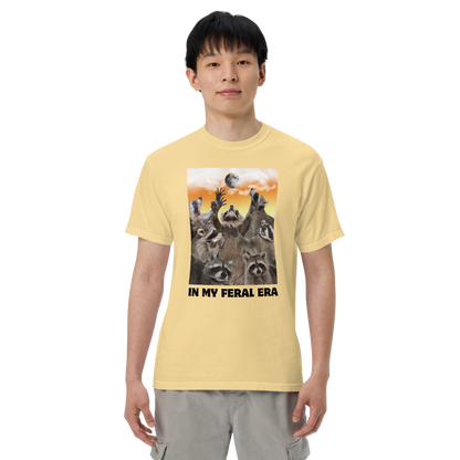 Man wearing a Funny In My Feral Era Raccoon heavyweight graphic t-shirt in butter yellow by Boozy Fox