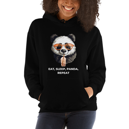 Smiling woman wearing a Black Panda Hoodie featuring the hilarious Eat, Sleep, Panda, Repeat graphic on the chest - Funny Graphic Panda Hoodies - Boozy Fox