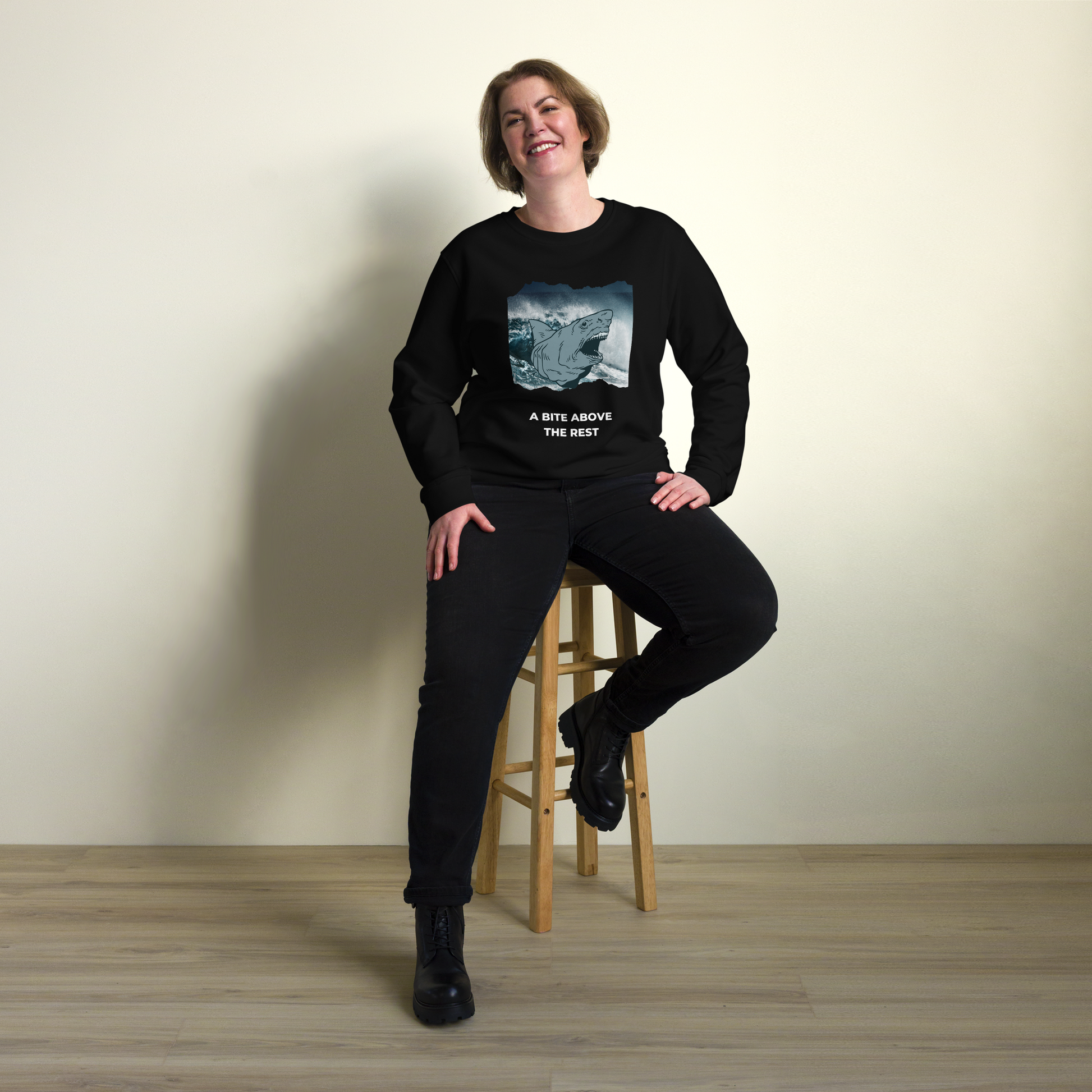 Smiling woman wearing a Black Organic Cotton Megalodon Sweatshirt featuring the jaw-dropping 'A Bite Above the Rest' graphic on the chest - Funny Graphic Megalodon Sweatshirts - Boozy Fox