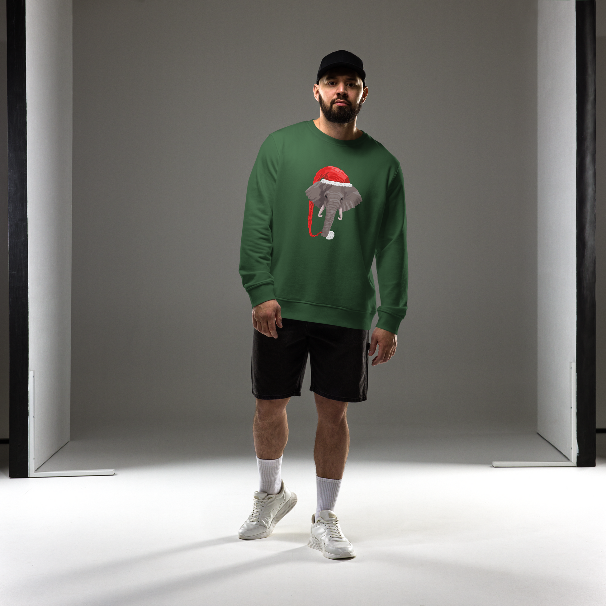 Man wearing a Bottle Green Organic Christmas Elephant Sweatshirt featuring a delight Elephant Wearing an Elf Hat graphic on the chest - Funny Christmas Graphic Elephant Sweatshirts - Boozy Fox