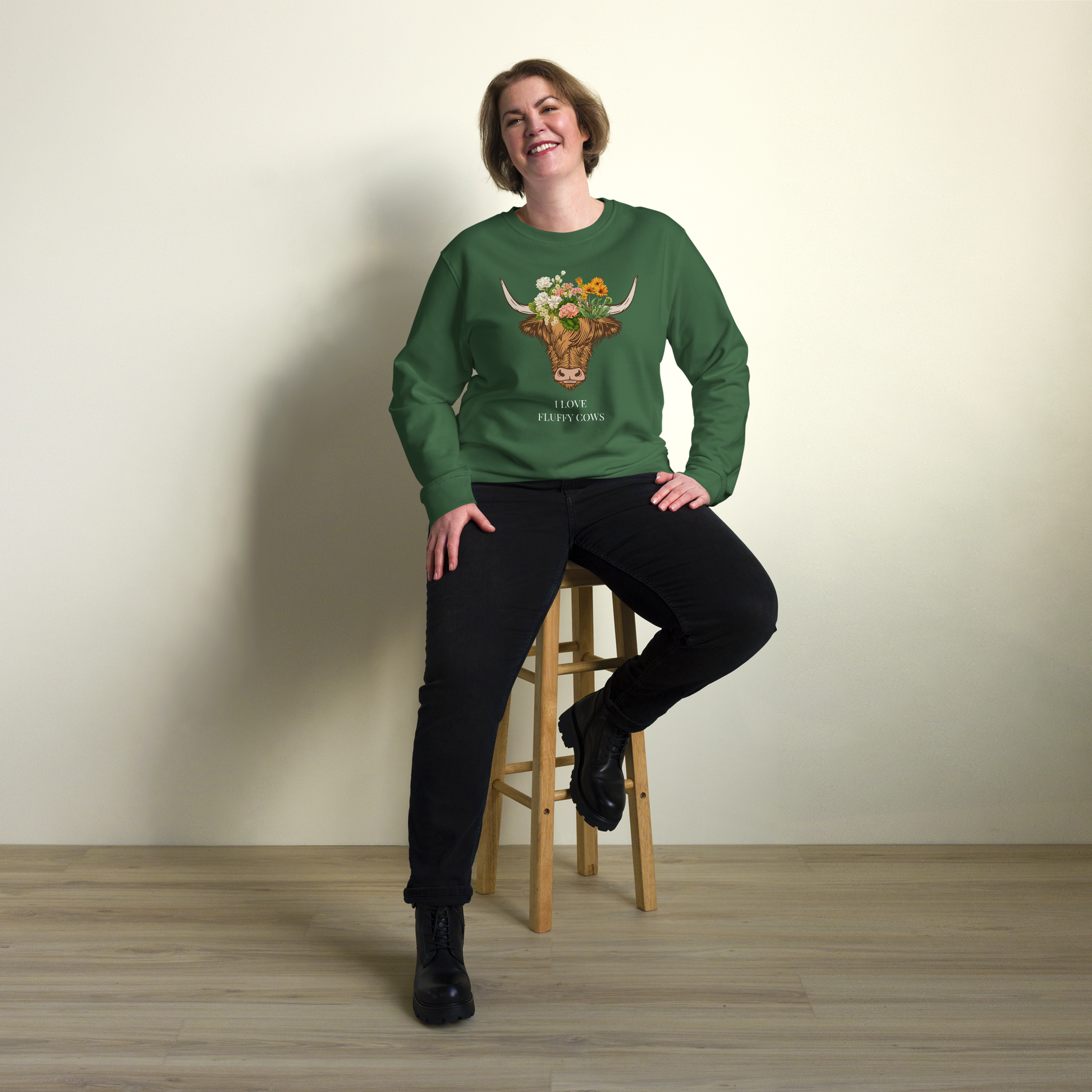 Smiling woman wearing a Bottle Green Organic Cotton Highland Cow Sweatshirt featuring an adorable I Love Fluffy Cows graphic on the chest - Cute Graphic Highland Cow Sweatshirts - Boozy Fox