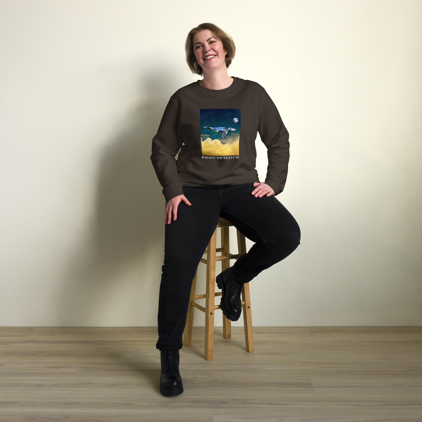 Smiling woman wearing a Deep Charcoal Grey Organic Cotton Whale Sweatshirt showcasing an enchanting Whale Under The Moon graphic on the chest - Cool Whale Graphic Sweatshirts - Boozy Fox