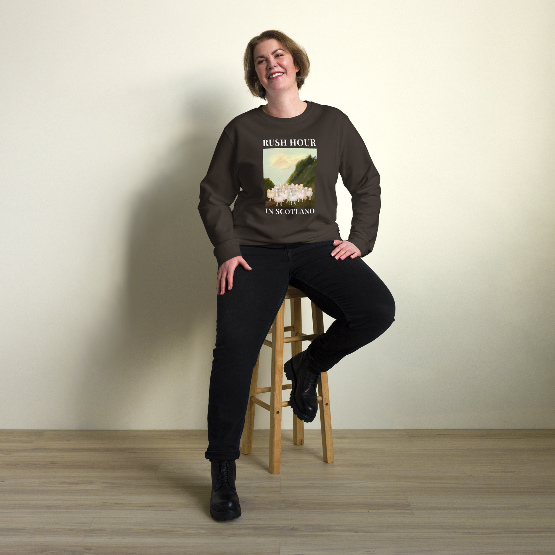 Woman wearing a Deep Charcoal Grey Sheep Organic Sweatshirt featuring a comical Rush Hour In Scotland graphic on the chest - Artsy & Funny Graphic Sheep Sweatshirts - Boozy Fox