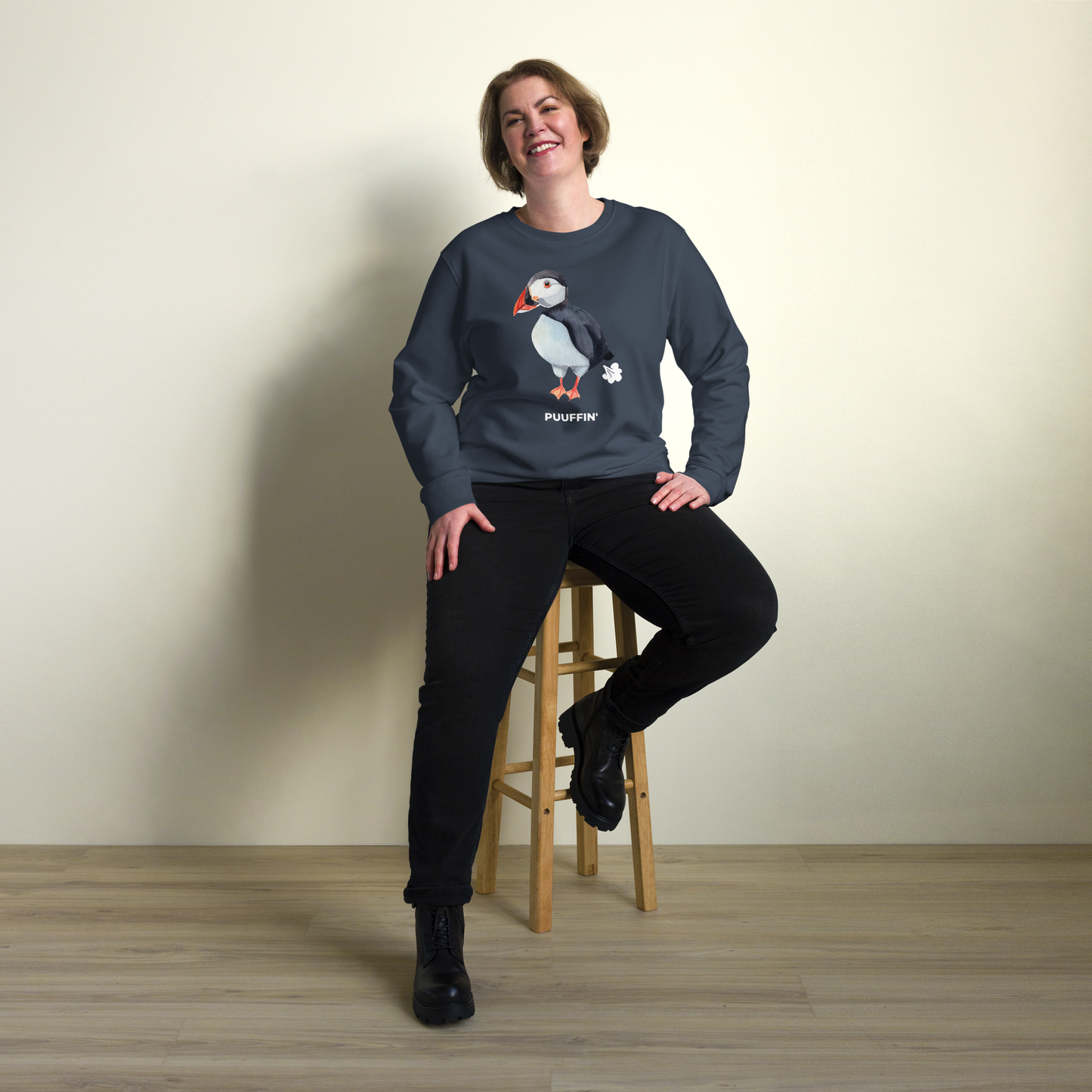 Smiling woman wearing a French Navy Organic Cotton Puffin Sweatshirt featuring a comic Puuffin' graphic on the chest - Funny Graphic Puffin Sweatshirts - Boozy Fox