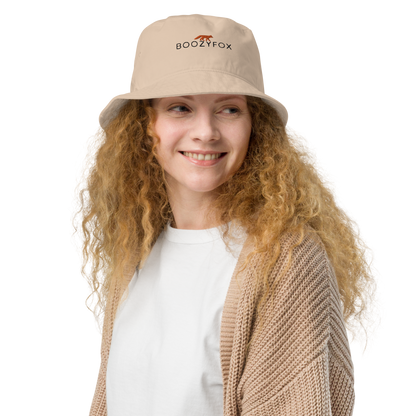 Smiling woman wearing a Stone Colored Organic Bucket Hat featuring a recognizable Boozy Fox embroidery logo on the front - Bucket Hats - Boozy Fox